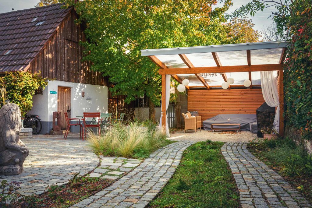 Garten mit Holz-Carport, Pflanzflächen und naturnaher Gartengestaltung in Gundelfingen.