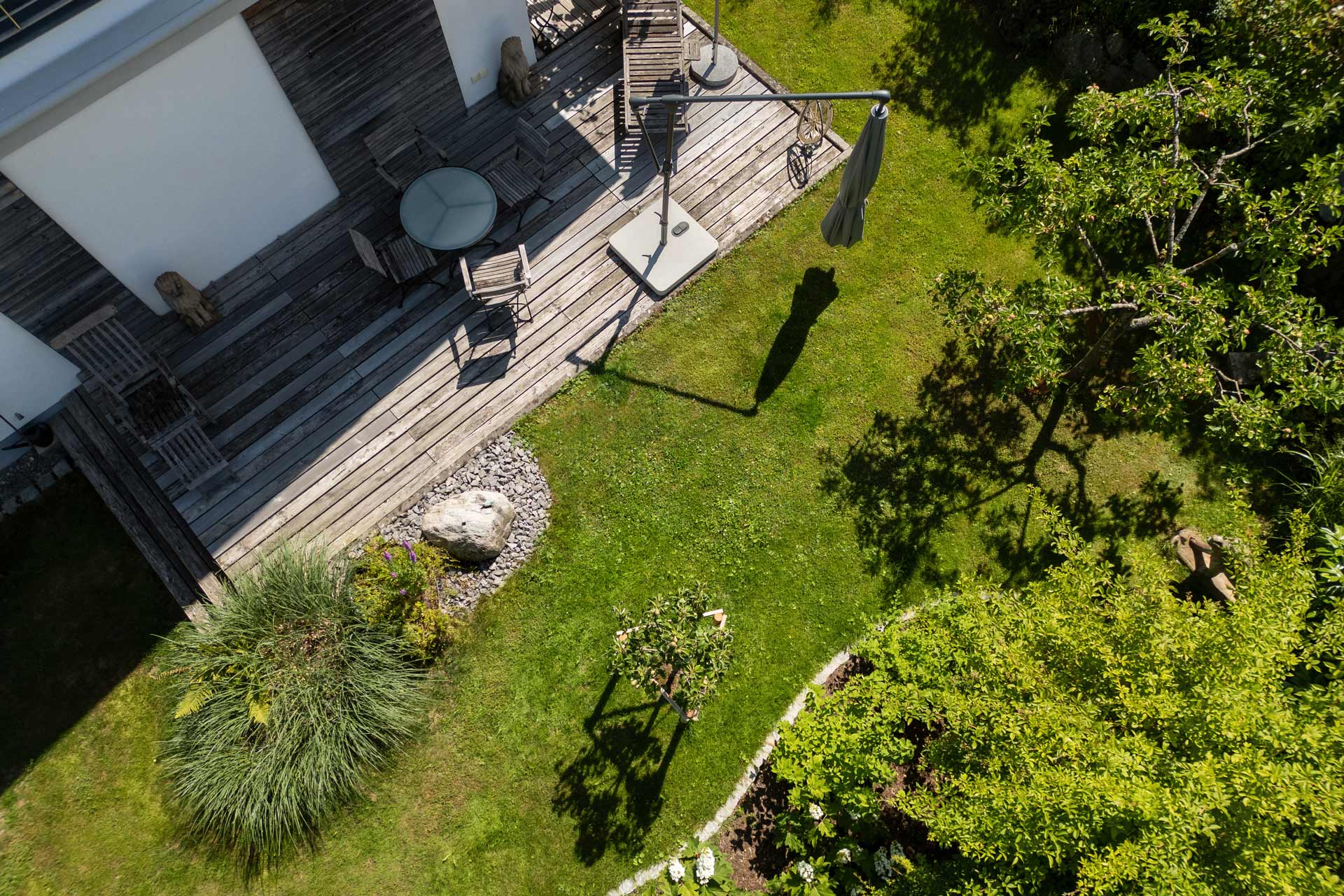Moderne Aussenanlage Terrasse mit Sitzplatz Wasserspiel und klimafeste Bepflanzung im Privatgarten.